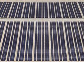 flygdrönare bild av solpaneler installerade på taket av en stor industribyggnad eller ett lager. industriella byggnader. den förnybara energin hållbara källor grön el solceller. foto