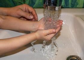 närbild av kaukasisk man och barn tvättar händerna i badrummet. covid - 19 förebyggande foto