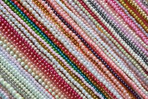diagonala linjer mönster av flerfärgade pärlhalsband tillbehör bakgrund, färgglada mönster av plastpärlor rad i hantverk fashionabla foto