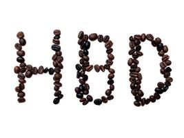 grattis på födelsedagen bokstäver av rostade kaffebönor bruna och mörka frö variation på vit bakgrund foto
