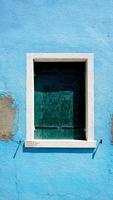 fönster i burano på blå förfallsvägg foto