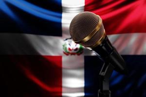 mikrofon på bakgrunden av dominicanas nationella flagga, realistisk 3d-illustration. musikpris, karaoke, radio och ljudutrustning för inspelningsstudio foto