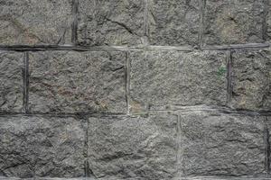 den antika väggen är belagd med gråsten, ovanifrån. sten textur, utomhus sten kakel foto