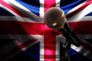 mikrofon på bakgrunden av Storbritanniens nationella flagga, realistisk 3d-illustration. musikpris, karaoke, radio och ljudutrustning för inspelningsstudio foto