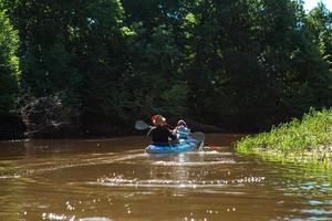 man och kvinna par i familjen kajak tur roddbåt på floden, en vattenvandring, ett sommaräventyr. miljövänlig och extrem turism, aktiv och hälsosam livsstil foto