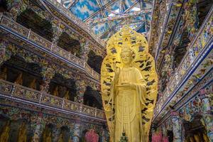 linh phuoc-pagoden i da lat, vietnam. dalats berömda landmärke, buddhistiska porslinsglastempel. gyllene guanyin-statyn vid linh phuoc-pagoden är också känd som ve chai-pagoden foto