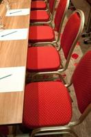 röda metalliska stolar i ett konferensrum