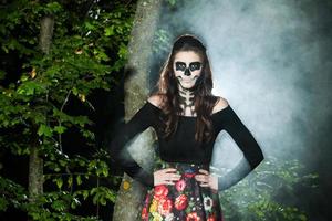 halloween vampyr kvinna porträtt över skrämmande natt bakgrund. vampyr smink mode konstdesign. modell flicka i halloween kostym och smink. foto