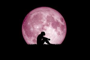 desperat och ensam man i bakgrunden av månen på natten. desperata, hjärtskärande och ensamma koncept foto