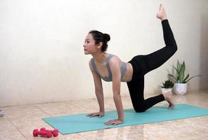en kvinna som gör yogaträning hemma foto