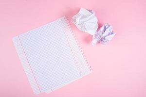 blankt papper och skrynkliga pappersvaddar på rosa bakgrund. söka inspiration, skriva planer. foto