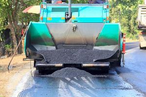 maskiner häller asfalt på vägar under konstruktion och reparation. och ny konstruktion gör det bekvämare att resa på landsbygden i Thailand. foto