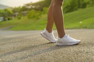 närbild av passform sportig kvinnas ben i löparskor, hälsa och sport koncept. foto