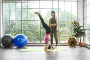 fit unga vän kvinnor gör yoga och meditation hemma, sport och hälsosam livsstil koncept. foto