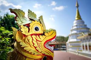 asien guld rött lejon staty med tempel bakgrund. foto