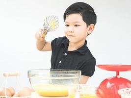 asiatisk pojke gör tårta foto