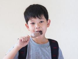 pojke äter glass. fotot är fokuserat på hans ögon. foto