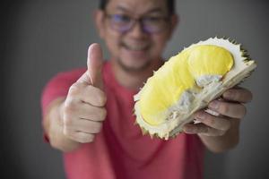 asiatisk man visar mogen durian lyckligt foto