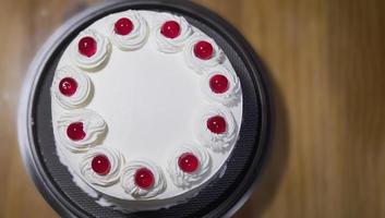 vit gräddtårta med röd jelly boll topping - hemlagat bageri koncept foto