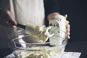 dam gör tårta sätta grädde med spatel - hemlagad bageri matlagning koncept foto