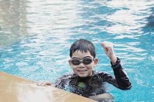 asiatisk glad unge spelar i poolen foto