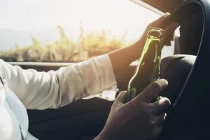 kvinna som håller ölflaska medan du kör bil foto