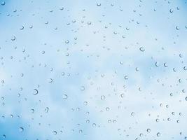 regn droppe pinne vid glasfönstret över blå himmel bakgrund foto