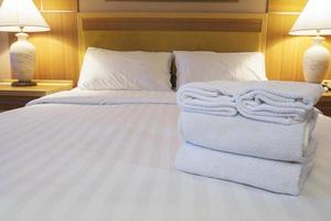 vita sängkläder och handdukar i modernt hotell foto