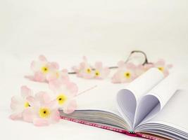söt rosa dagbok med hjärtformat papper och konstgjord blomma foto