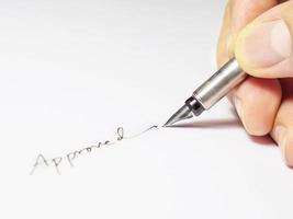 hand signering godkännande ord ett vitt papper foto