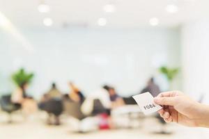 man håller kökort medan han väntar i det moderna receptionsområdet foto