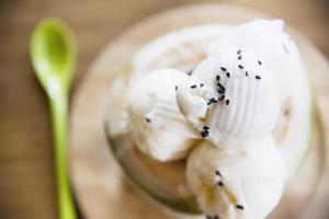 kokosglass servering i färskt kokosnötskal på träbord - välsmakande berömd söt dessert foto