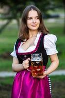 sexig rysk kvinna i bayersk klänning som håller ölmuggar. foto