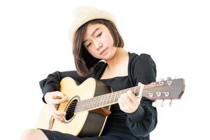 kvinna sitter och spelar gitarr gitarr folksång i hennes hand foto