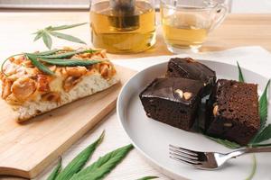mat och dryck och cannabisblad på matbordet. alternativ medicin koncept. foto