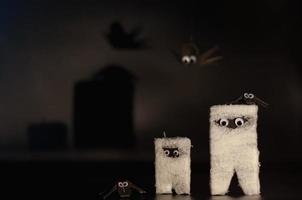 halloweenmumien som gjordes av papper och bandage med origami eller pappersvikbara fladdermöss på svart bakgrund. foto