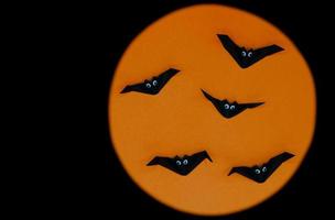 halloween origami eller pappersvikning av fladdermöss isolerad på orange och svart bakgrund. foto