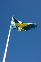svenska flaggan som blåser i vinden foto