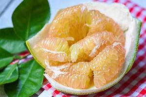 färsk grön pomelo och blad från pomeloträd, pummelo, grapefrukt på sommaren tropisk frukt i thailand, pomelo frukt på skalbakgrund foto