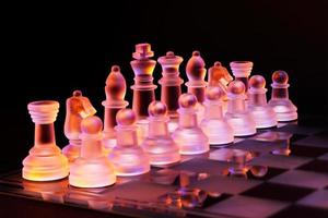 glasschack på schackbrädet tänd av blått och orange ljus foto