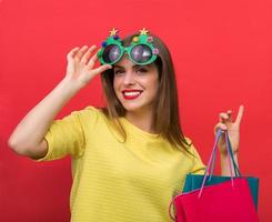 kvinna med julfestglasögon och shoppingväskor foto