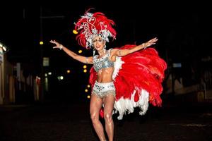 brasiliansk klädd samba-dräkt. vacker brasiliansk kvinna klädd i färgglad kostym och ler under karnevalsgatans parad i Brasilien. foto