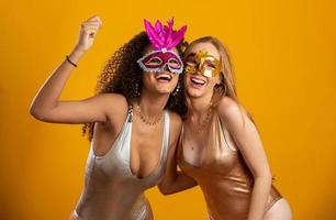 vackra kvinnor klädda för karnevalskväll. leende kvinnor redo att njuta av karnevalen med en färgglad mask. foto