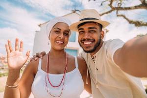 turist gör en selfie med en bahian kvinna. glad brasiliansk kvinna klädd i den traditionella bahianska dräkten av umbanda-religionen foto
