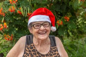 senior kvinna i santa hatt smilling. foto