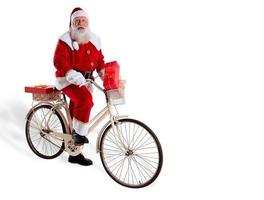 Jultomten på cykel levererar julklappar. foto