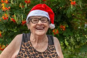 senior kvinna i santa hatt smilling. foto