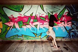 Polen, 2022 - snygg tjej i danspose mot graffitivägg foto