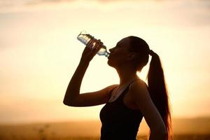 kvinna siluett dricksvatten foto