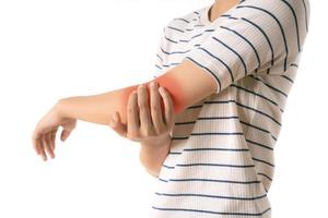 flicka tar tag i handen på armbågen på grund av smärta. foto